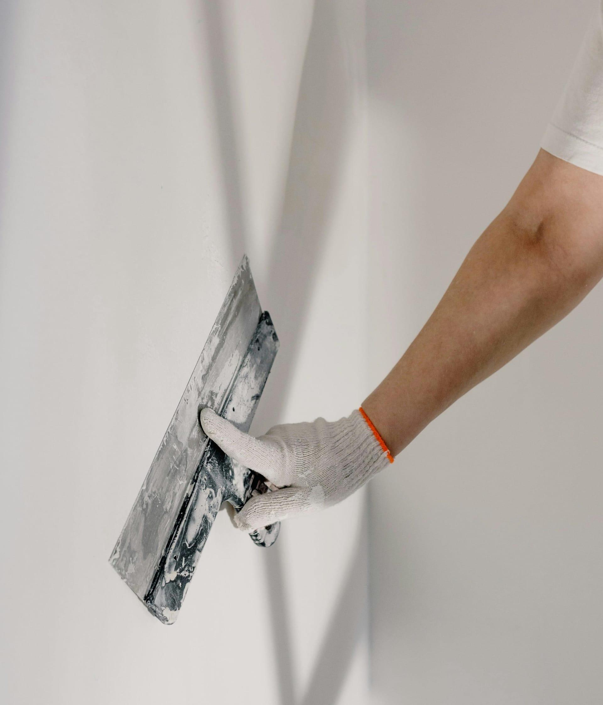 Detailaufnahme einer für den Anstrich gespachtelten und geschliffenen Wand mit sauberen Eckschutzprofilen.